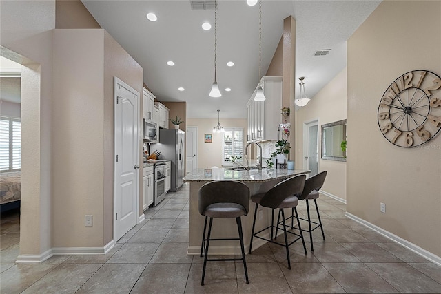 166 Midway Park Dr, Saint Augustine, FL 32084 - kitchen featuring a breakfast bar, healthy amount of natural light, stainless steel appliances, white cabinetry, and lofted ceiling
