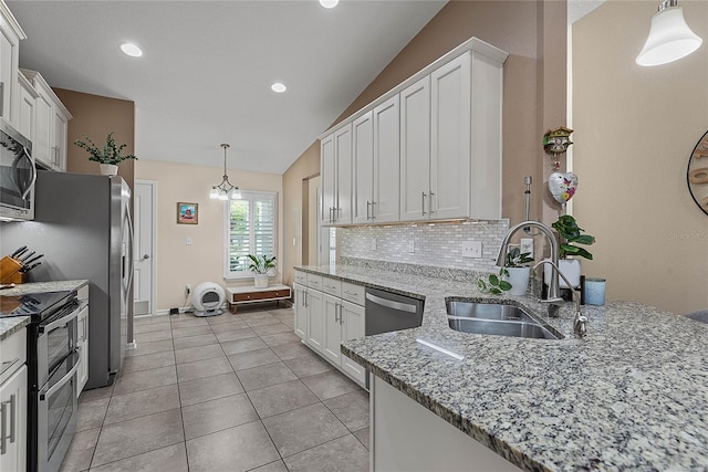166 Midway Park Dr, Saint Augustine, FL 32084 - kitchen with stainless steel appliances, white cabinetry, lofted ceiling, backsplash, and light stone counters
