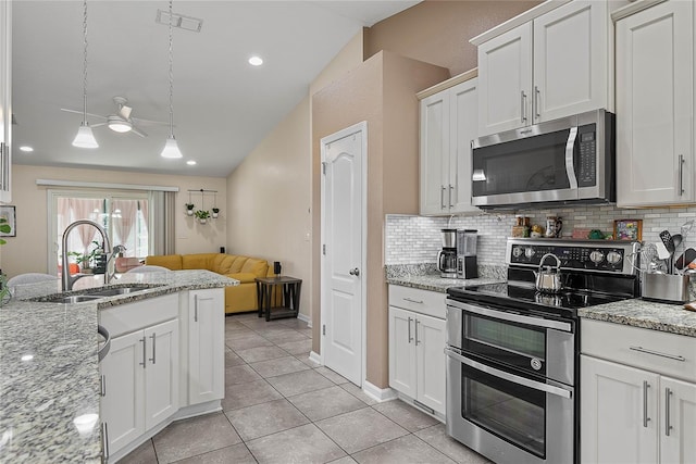 166 Midway Park Dr, Saint Augustine, FL 32084 - kitchen featuring stainless steel appliances, tasteful backsplash, white cabinetry, and lofted ceiling