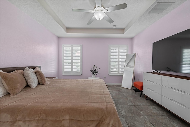 166 Midway Park Dr, Saint Augustine, FL 32084 - bedroom featuring a tray ceiling, multiple windows, a ceiling fan, and dark tile patterned floors