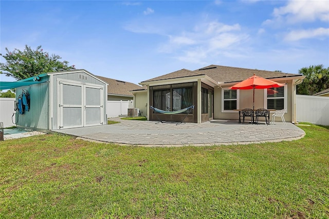 166 Midway Park Dr, Saint Augustine, FL 32084 - rear view of house featuring a sunroom, a storage unit, a patio, a fenced backyard, and roof with shingles