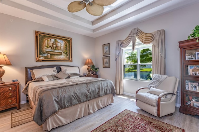 25 Raintree Cir, Palm Coast, FL 32164 - bedroom with light wood-type flooring, a tray ceiling, and a ceiling fan
