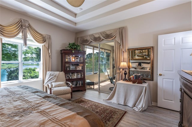 25 Raintree Cir, Palm Coast, FL 32164 - bedroom featuring access to exterior, light wood-style floors, and a tray ceiling