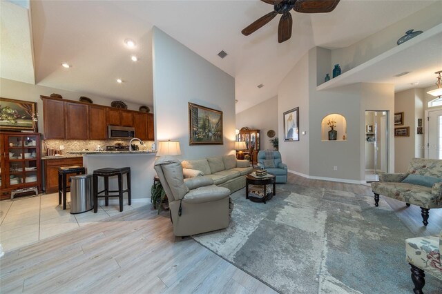 25 Raintree Cir, Palm Coast, FL 32164 - living room featuring a ceiling fan, high vaulted ceiling, and light wood-type flooring