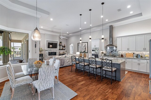 4 Old Oak Dr N, Palm Coast, FL 32137 - dining room featuring ceiling fan, dark wood-style flooring, a fireplace, recessed lighting, and a high ceiling
