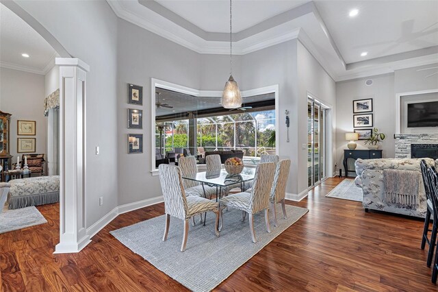 4 Old Oak Dr N, Palm Coast, FL 32137 - dining room featuring wood finished floors, a raised ceiling, arched walkways, crown molding, and a high ceiling