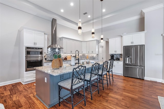 4 Old Oak Dr N, Palm Coast, FL 32137 - kitchen with stainless steel appliances, wall chimney exhaust hood, backsplash, a large island with sink, and white cabinets