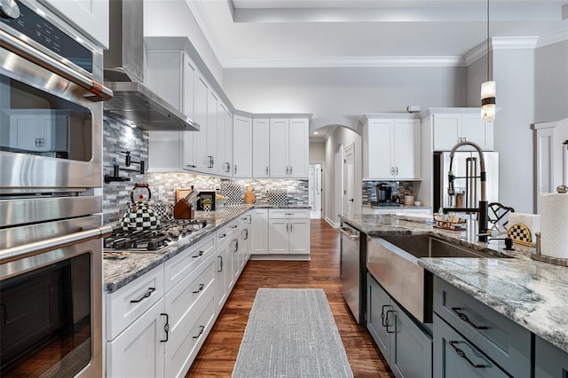 4 Old Oak Dr N, Palm Coast, FL 32137 - kitchen featuring appliances with stainless steel finishes, arched walkways, wall chimney exhaust hood, gray cabinets, and dark wood-style floors