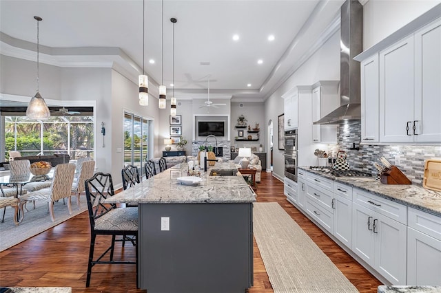 4 Old Oak Dr N, Palm Coast, FL 32137 - kitchen with wall chimney range hood, ceiling fan, open floor plan, a kitchen bar, and tasteful backsplash