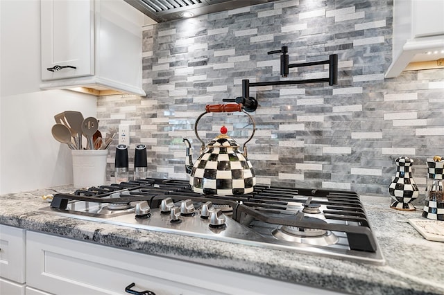 4 Old Oak Dr N, Palm Coast, FL 32137 - kitchen featuring backsplash, stainless steel gas stovetop, white cabinets, exhaust hood, and light stone counters