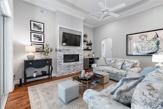 4 Old Oak Dr N, Palm Coast, FL 32137 - living area featuring arched walkways, a ceiling fan, wood finished floors, a stone fireplace, and a towering ceiling
