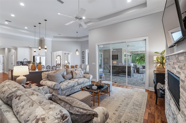 4 Old Oak Dr N, Palm Coast, FL 32137 - living room with arched walkways, a ceiling fan, a towering ceiling, a fireplace, and dark wood-type flooring