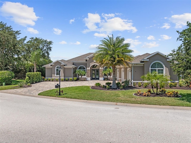 4 Old Oak Dr N, Palm Coast, FL 32137 - mediterranean / spanish house with stucco siding, a front yard, decorative driveway, and french doors