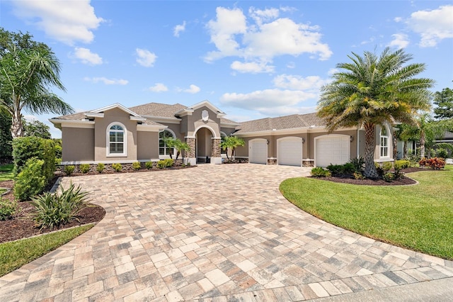 4 Old Oak Dr N, Palm Coast, FL 32137 - mediterranean / spanish house featuring a garage, stucco siding, decorative driveway, and a front yard