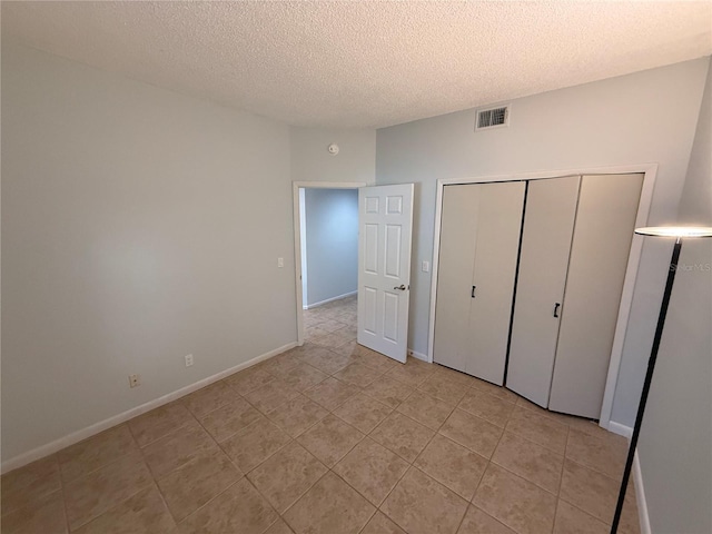 59 Rivers Edge Ln Unit 59, Palm Coast, FL 32137 - unfurnished bedroom with a textured ceiling, light tile patterned floors, and a closet