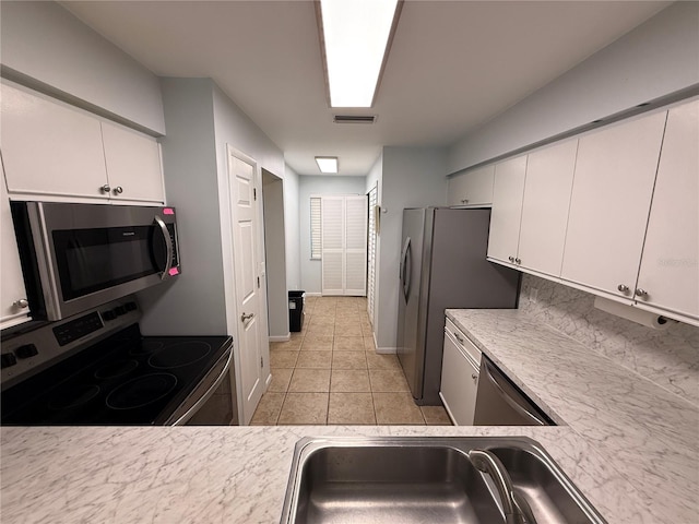 59 Rivers Edge Ln Unit 59, Palm Coast, FL 32137 - kitchen with stainless steel appliances, white cabinetry, light countertops, and light tile patterned flooring