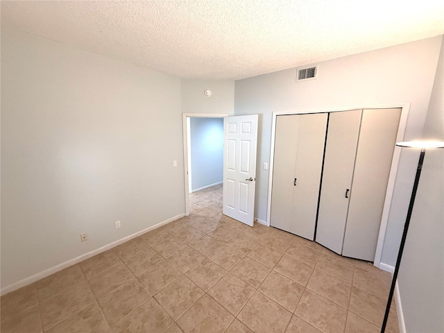 59 Rivers Edge Ln Unit 59, Palm Coast, FL 32137 - unfurnished bedroom with a textured ceiling, light tile patterned flooring, and a closet