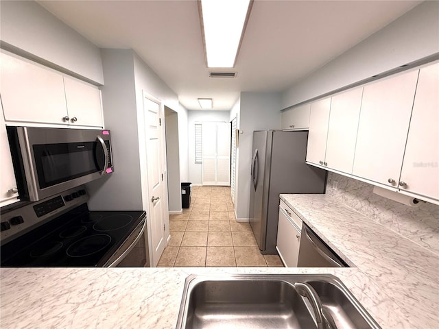 59 Rivers Edge Ln Unit 59, Palm Coast, FL 32137 - kitchen featuring appliances with stainless steel finishes, light countertops, white cabinets, and light tile patterned flooring
