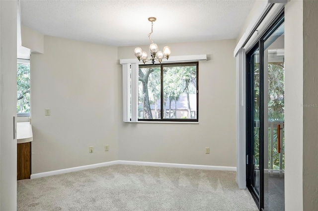 14 Oakmont Ct Unit 14, Palm Coast, FL 32137 - spare room featuring a chandelier, carpet floors, and a textured ceiling
