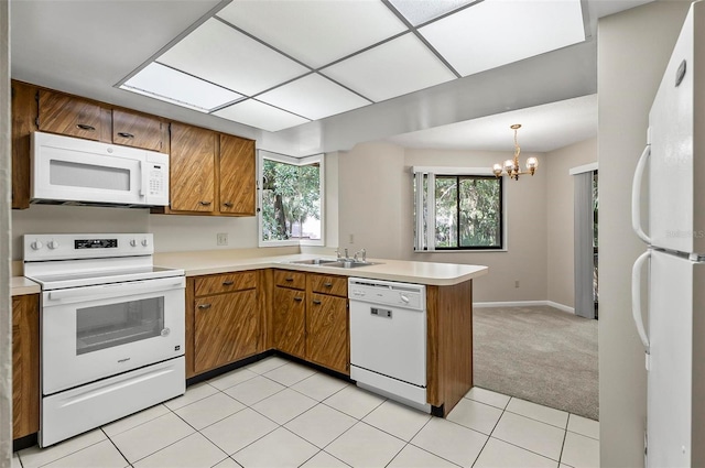 14 Oakmont Ct Unit 14, Palm Coast, FL 32137 - kitchen with white appliances, brown cabinets, a peninsula, light countertops, and a chandelier