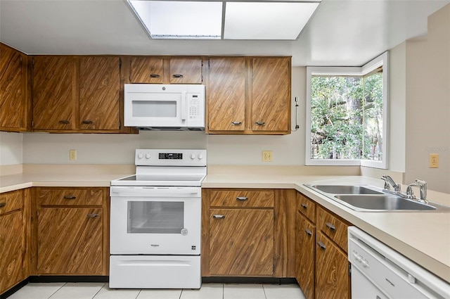 14 Oakmont Ct Unit 14, Palm Coast, FL 32137 - kitchen featuring white appliances, light tile patterned floors, brown cabinets, and light countertops