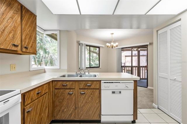 14 Oakmont Ct Unit 14, Palm Coast, FL 32137 - kitchen with white appliances, brown cabinetry, a chandelier, a peninsula, and light countertops