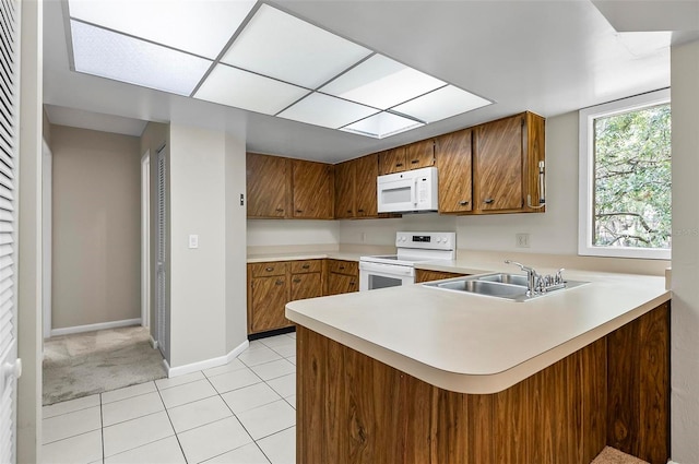 14 Oakmont Ct Unit 14, Palm Coast, FL 32137 - kitchen with white appliances, brown cabinetry, light countertops, a peninsula, and light tile patterned floors