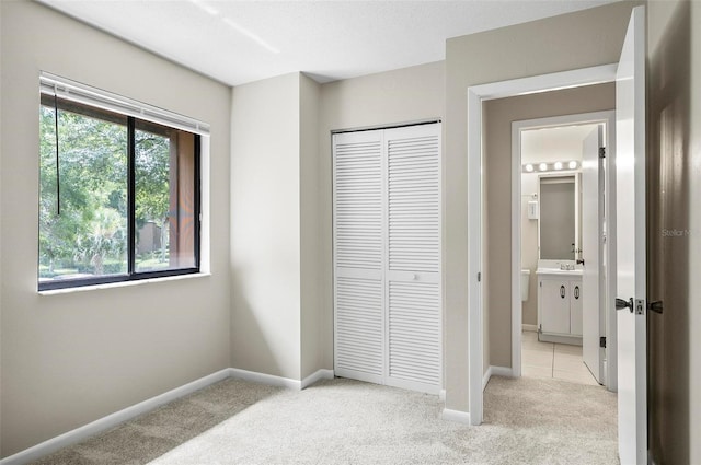 14 Oakmont Ct Unit 14, Palm Coast, FL 32137 - unfurnished bedroom featuring light carpet, a closet, and ensuite bathroom