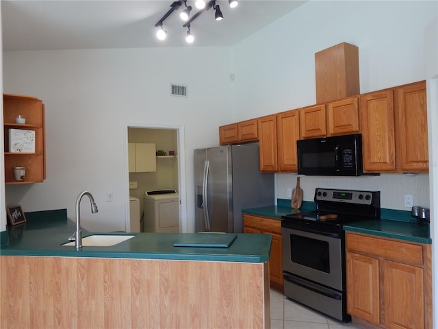 7 College Ct, Palm Coast, FL 32137 - kitchen featuring appliances with stainless steel finishes, washing machine and dryer, a peninsula, dark countertops, and a high ceiling