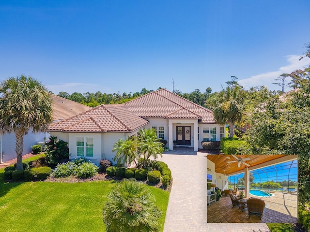 145 Heron Dr, Palm Coast, FL 32137 - mediterranean / spanish house featuring a tiled roof, stucco siding, a front lawn, and ceiling fan