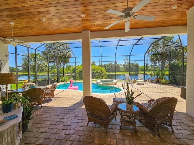 145 Heron Dr, Palm Coast, FL 32137 - view of swimming pool with ceiling fan, a water view, a pool with connected hot tub, a lanai, and a patio