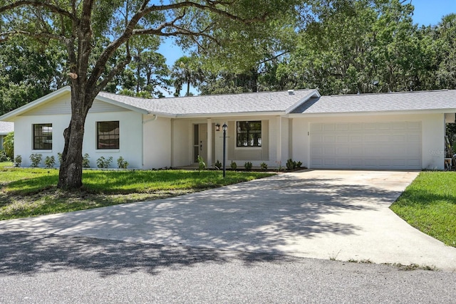 43 Courtney Pl, Palm Coast, FL 32137 - ranch-style home featuring driveway, a garage, a front lawn, stucco siding, and a shingled roof