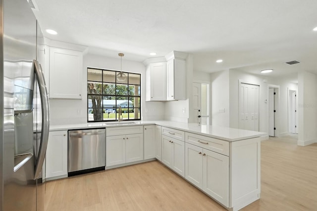 43 Courtney Pl, Palm Coast, FL 32137 - kitchen featuring stainless steel appliances, a peninsula, light wood-type flooring, recessed lighting, and white cabinets