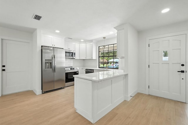 43 Courtney Pl, Palm Coast, FL 32137 - kitchen featuring stainless steel appliances, light wood-type flooring, a peninsula, recessed lighting, and white cabinets
