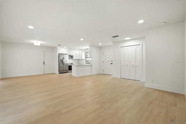 43 Courtney Pl, Palm Coast, FL 32137 - unfurnished living room with recessed lighting and light wood-style flooring