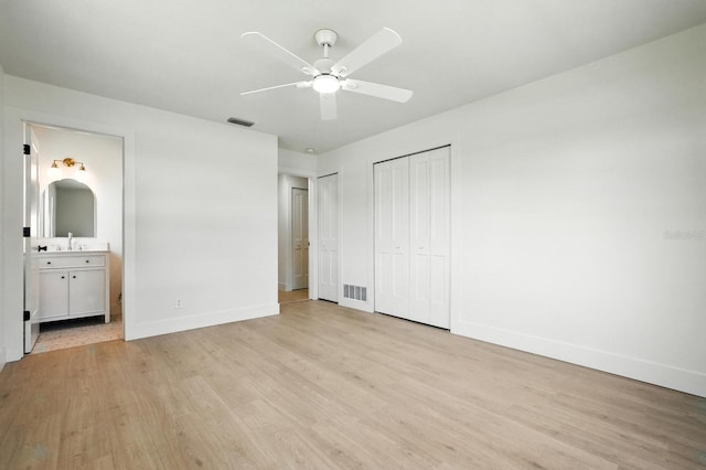 43 Courtney Pl, Palm Coast, FL 32137 - unfurnished bedroom featuring light wood-type flooring, multiple closets, connected bathroom, and a ceiling fan