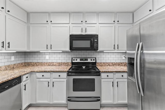 4600 E Moody Blvd Unit 14O, Bunnell, FL 32110 - kitchen with stainless steel appliances, white cabinets, decorative backsplash, and light stone countertops