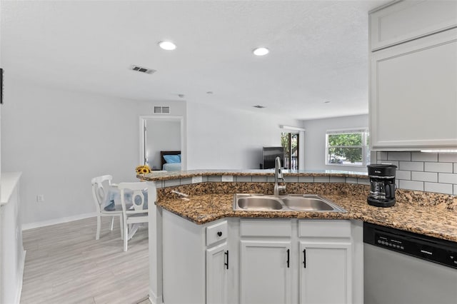4600 E Moody Blvd Unit 14O, Bunnell, FL 32110 - kitchen with dishwasher, white cabinetry, recessed lighting, light wood-style flooring, and backsplash
