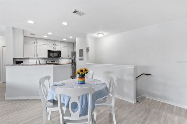 4600 E Moody Blvd Unit 14O, Bunnell, FL 32110 - dining room featuring light wood finished floors, recessed lighting, and electric panel