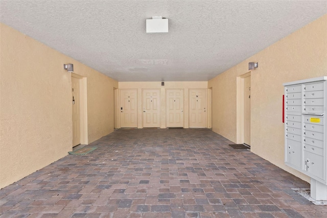 4600 E Moody Blvd Unit 14O, Bunnell, FL 32110 - hallway with a textured ceiling, brick flooring, a textured wall, and mail area