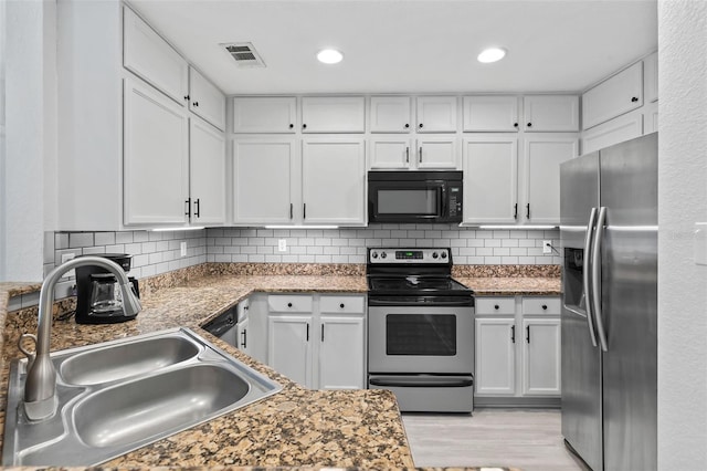 4600 E Moody Blvd Unit 14O, Bunnell, FL 32110 - kitchen with stainless steel appliances, white cabinets, tasteful backsplash, light wood-style floors, and recessed lighting