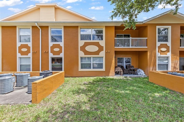 4600 E Moody Blvd Unit 14O, Bunnell, FL 32110 - rear view of house with a balcony, stucco siding, and a yard