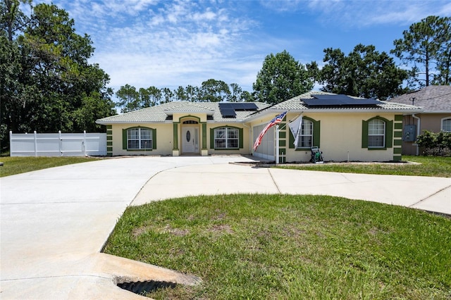 25 Raintree Pl, Palm Coast, FL 32164 - view of front facade with curved driveway, roof mounted solar panels, stucco siding, and a tile roof