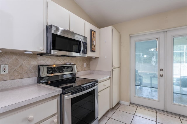 25 Raintree Pl, Palm Coast, FL 32164 - kitchen with appliances with stainless steel finishes, vaulted ceiling, light countertops, decorative backsplash, and white cabinetry