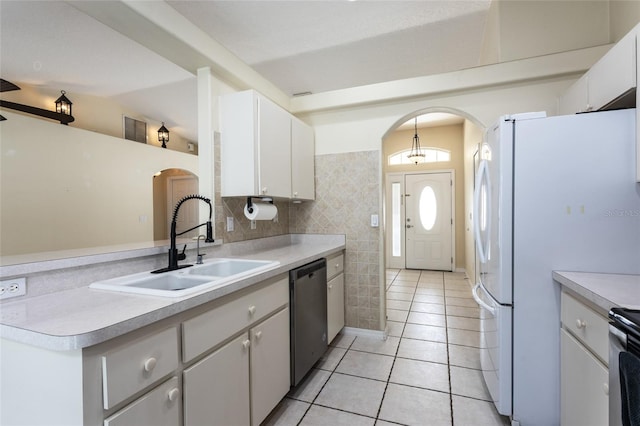 25 Raintree Pl, Palm Coast, FL 32164 - kitchen featuring dishwasher, arched walkways, light tile patterned floors, light countertops, and tile walls