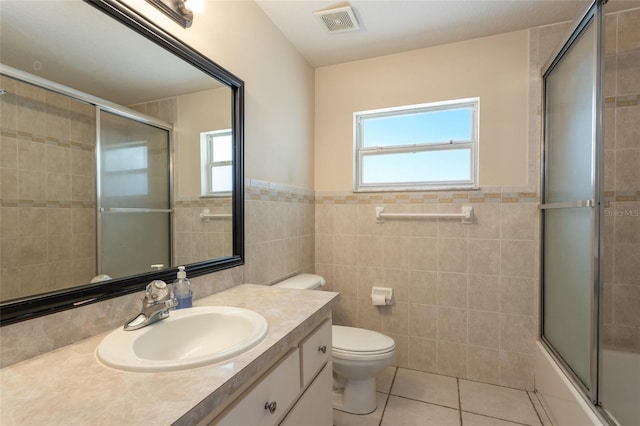 25 Raintree Pl, Palm Coast, FL 32164 - bathroom with tile walls, plenty of natural light, tile patterned flooring, vanity, and enclosed tub / shower combo