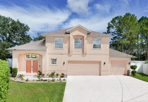 7 Flint Pl, Palm Coast, FL 32137 - view of front facade with stucco siding, concrete driveway, and an attached garage
