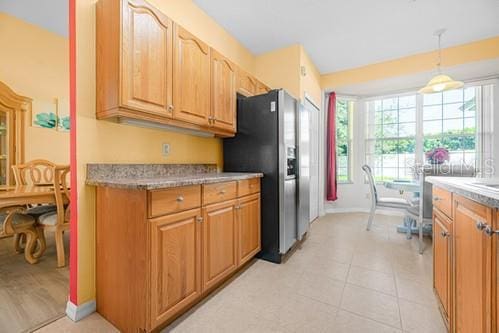 7 Flint Pl, Palm Coast, FL 32137 - kitchen with stainless steel fridge, light countertops, pendant lighting, and light tile patterned floors