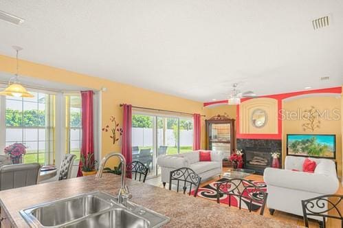 7 Flint Pl, Palm Coast, FL 32137 - kitchen with open floor plan, a ceiling fan, a fireplace, and decorative light fixtures