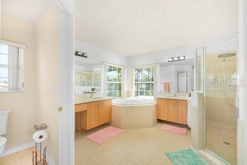 7 Flint Pl, Palm Coast, FL 32137 - full bath featuring two vanities, a stall shower, a garden tub, tile patterned flooring, and a textured ceiling